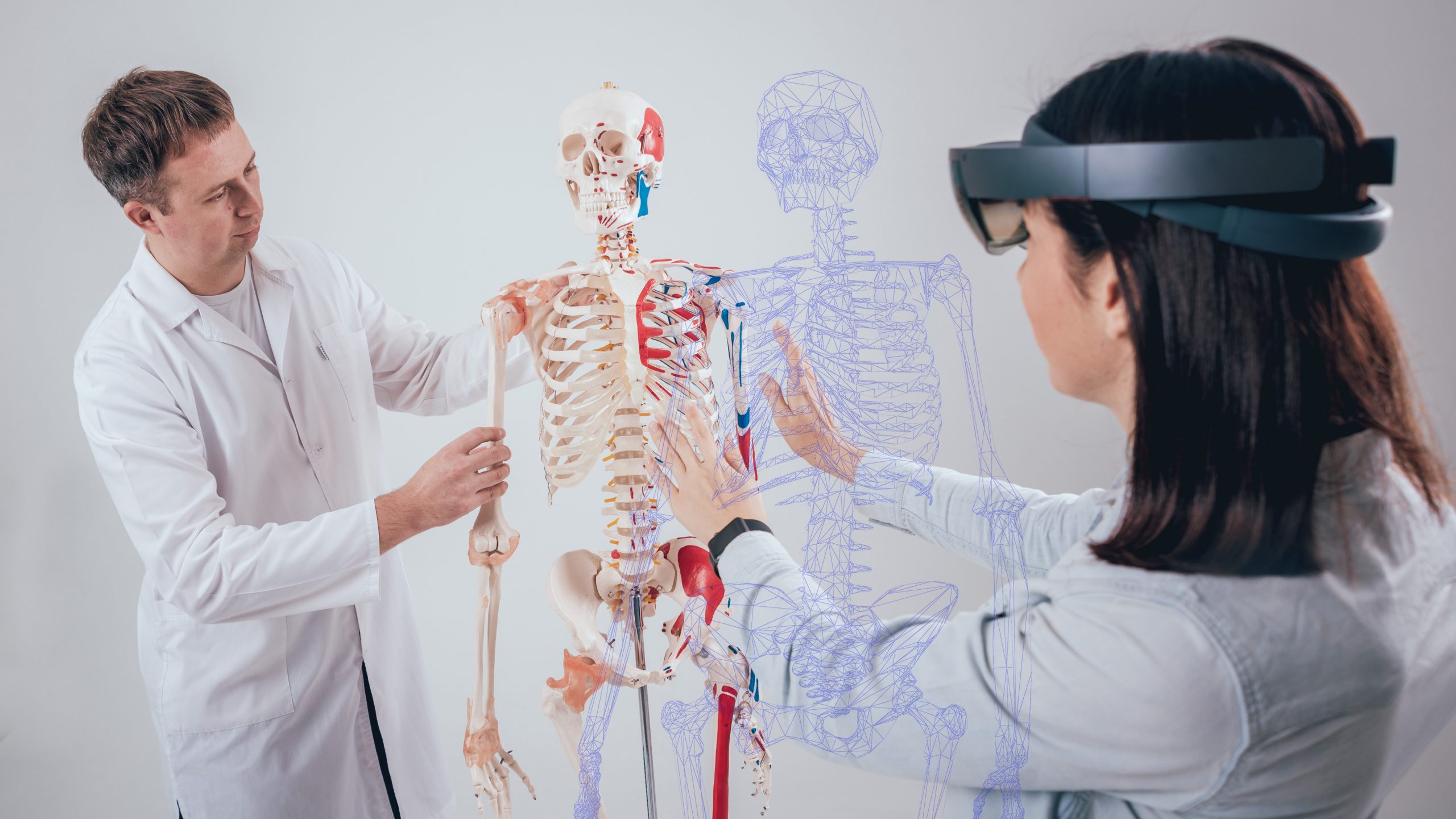 Doctor uses augmented reality goggles and human skeleton for teaching student